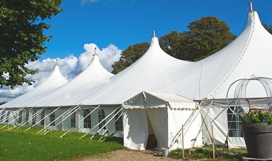 tall green portable restrooms assembled at a music festival, contributing to an organized and sanitary environment for guests in Rockwood